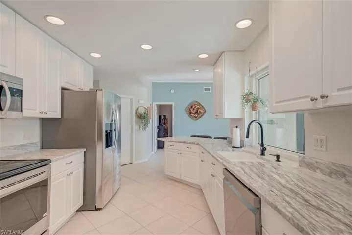 Kitchen featuring stainless steel appliances, white cabinetry, and recessed lighting