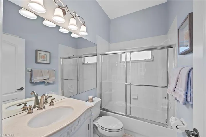 Full bath featuring enclosed tub / shower combo and vanity