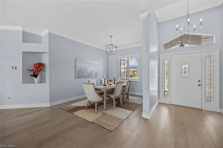 Entrance foyer featuring a chandelier, ornamental molding, and light wood-style floors