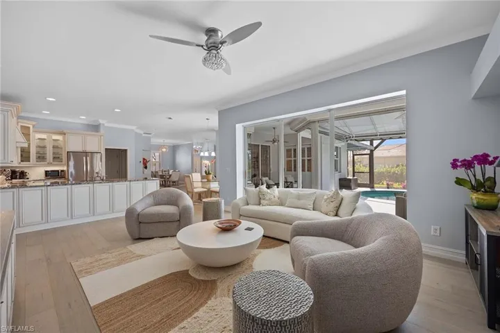 Living area with ornamental molding, a sunroom, ceiling fan, light wood-style flooring, and recessed lighting