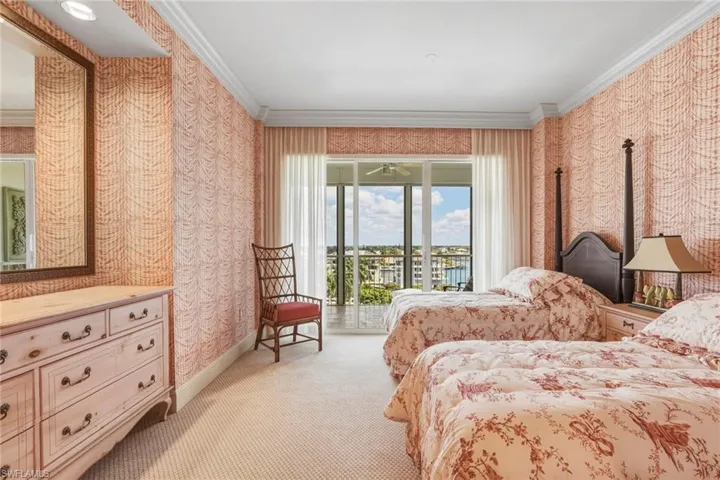 Carpeted bedroom featuring wallpapered walls, ornamental molding, and access to outside