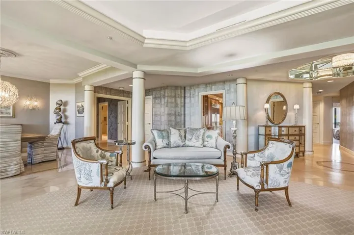 Common area with ornamental molding, wallpapered walls, and a raised ceiling