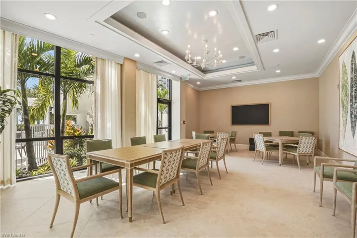 Dining room featuring hanging lights, ornamental molding, a tray ceiling, and floor to ceiling windows