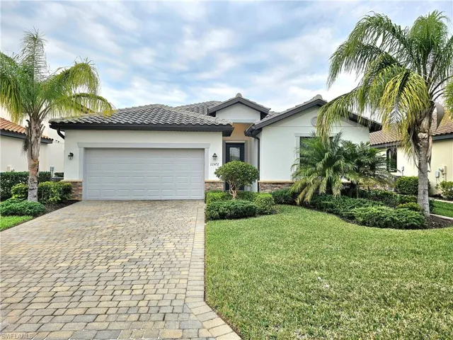View of front of home with a front yard and a garage