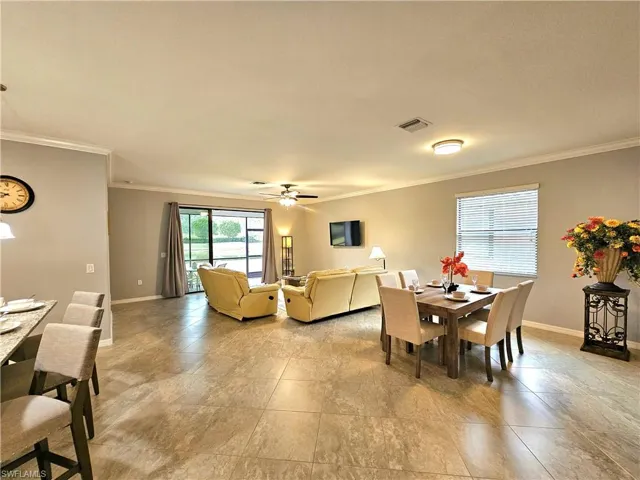 Dining area featuring ceiling fan and crown molding