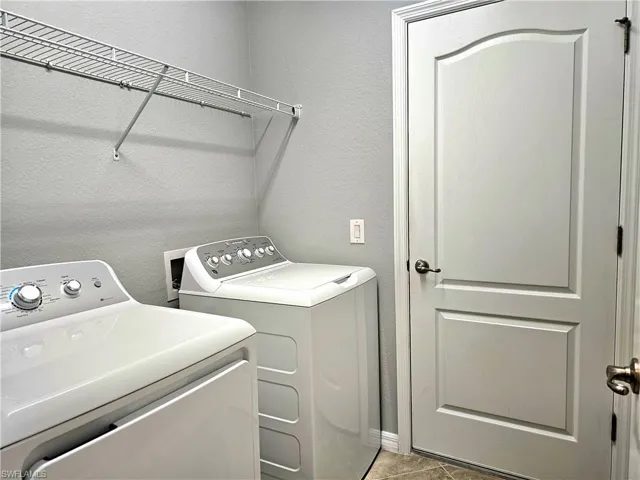 Laundry area with washer and dryer and tile patterned floors