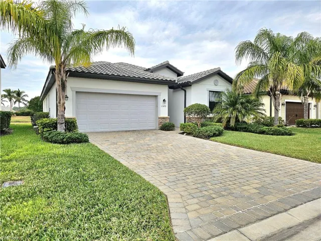 Mediterranean / spanish-style house with a garage and a front yard