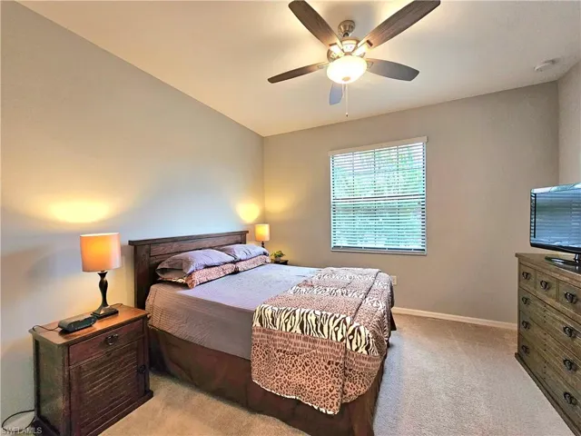 Bedroom with ceiling fan and light carpet