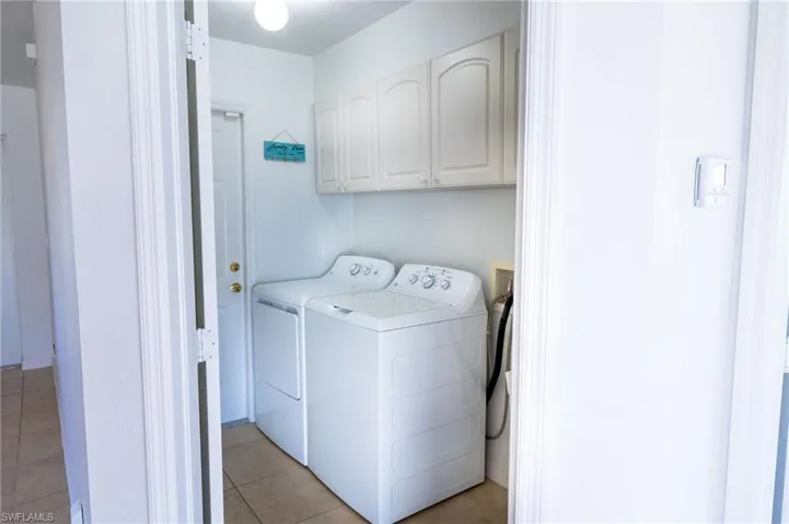 Washroom with cabinet space, washer and dryer, utility sink.