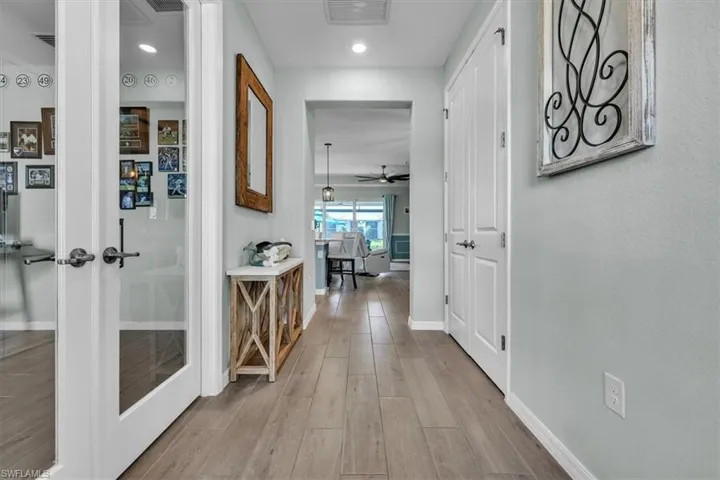 Hallway with wood-finish flooring, recessed lighting, and a neutral wall color