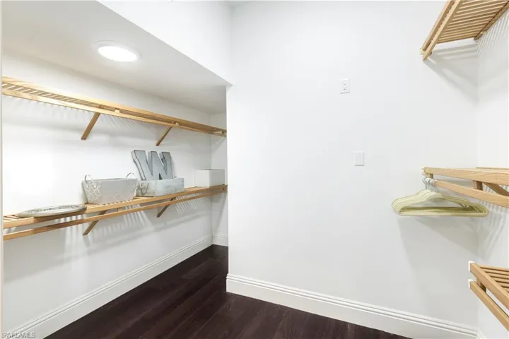 Large walk in Primary Closet w/wooden shelving plus added hidden storage space
