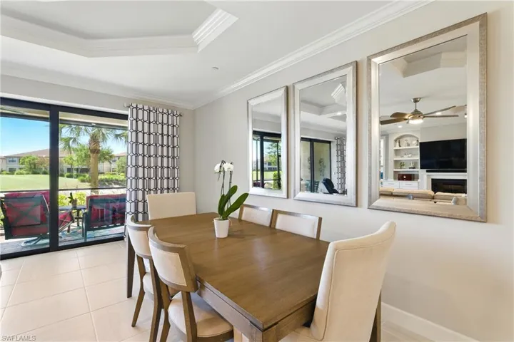 Dining area with light tile patterned flooring, built in features, a healthy amount of sunlight, and crown molding