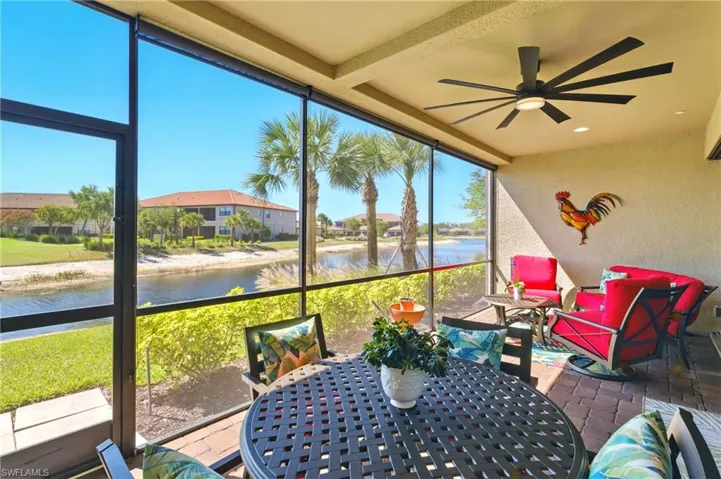 Sunroom / solarium with a ceiling fan, outdoor dining area, and a water view