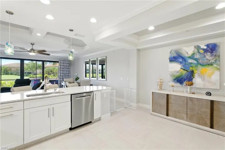 Kitchen with crown molding, ceiling fan, a sink, open floor plan, and stainless steel dishwasher