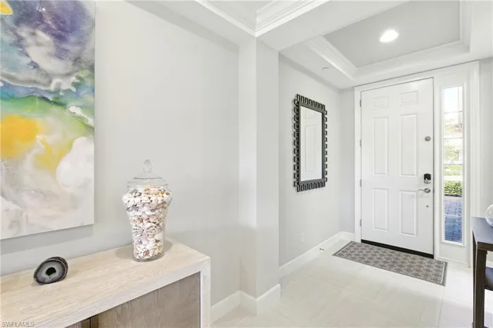 Entrance foyer featuring baseboards, ornamental molding, and a raised ceiling
