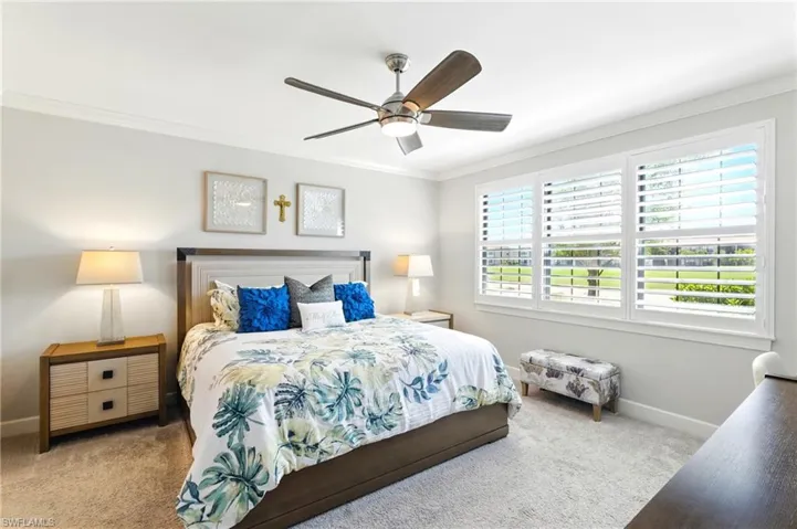 Bedroom featuring baseboards, carpet floors, ceiling fan, and crown molding