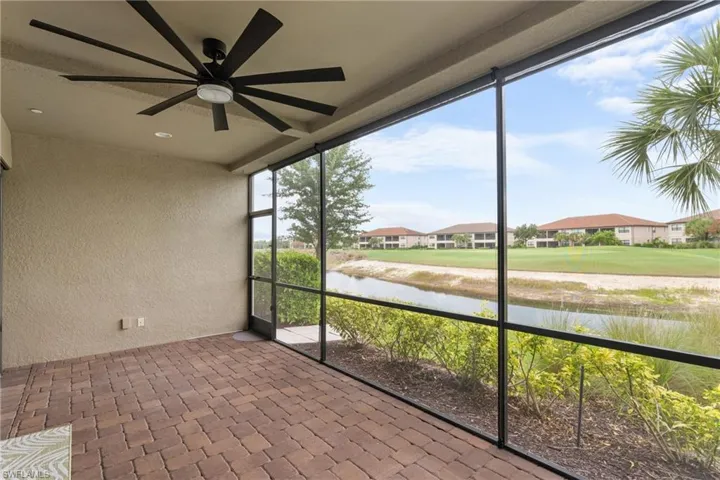 Unfurnished sunroom featuring ceiling fan and a water view