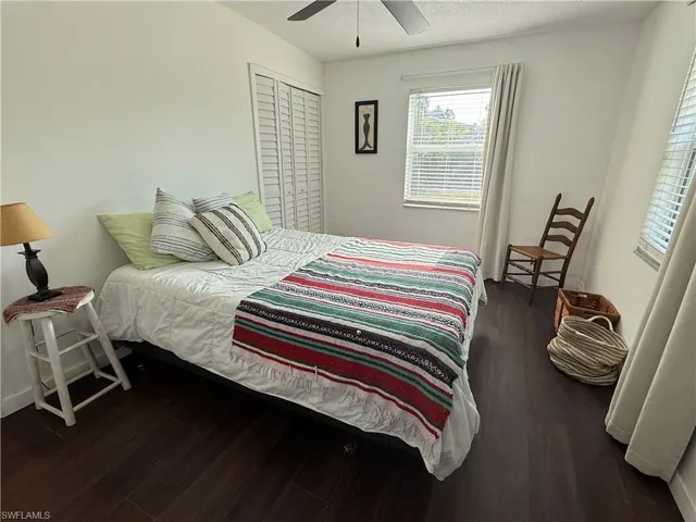 Bedroom featuring wood finished floors, a closet, a ceiling fan, and baseboards