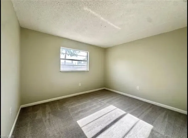 Spare room with a textured ceiling and carpet
