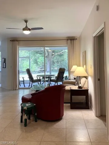 Living area featuring light tile patterned flooring and a ceiling fan
