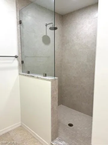 Bathroom featuring a walk in shower and light tile patterned floors