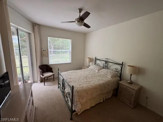 Bedroom featuring access to exterior, dark colored carpet, and ceiling fan