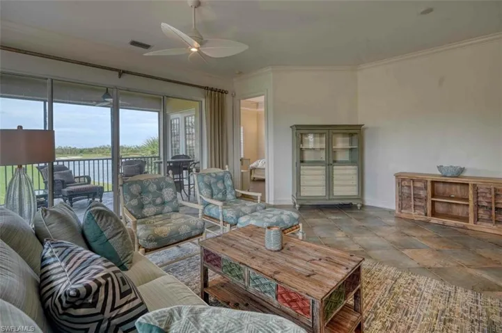 Living room featuring a water view, ceiling fan, and ornamental molding