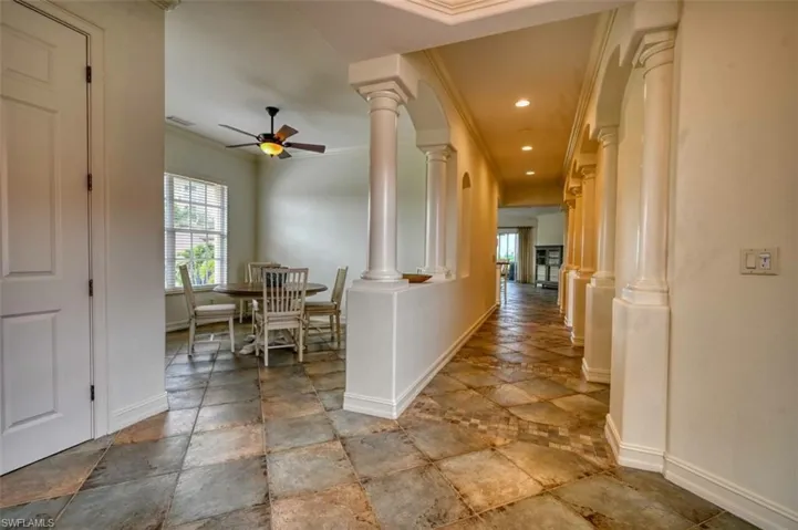Hallway featuring ornamental molding and ornate columns