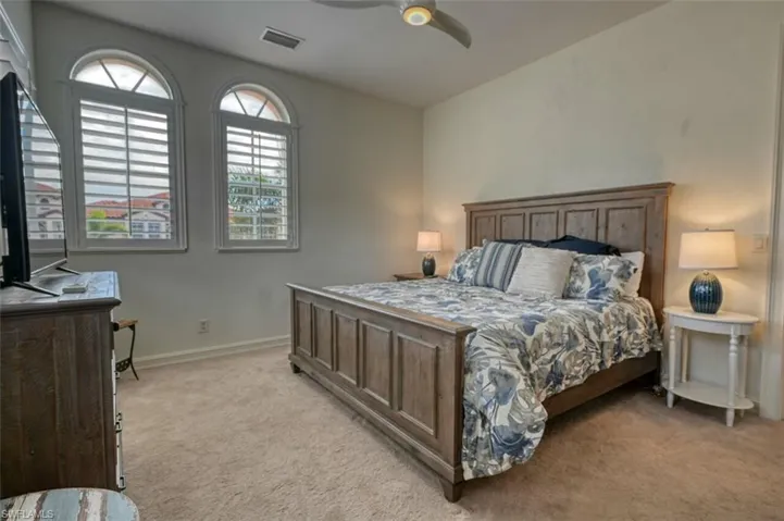Carpeted bedroom featuring ceiling fan