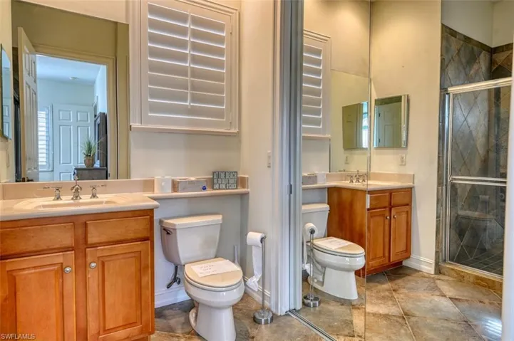 Bathroom with toilet, walk in shower, and vanity
