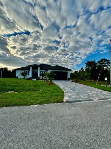 Ranch-style house featuring a front yard and a garage