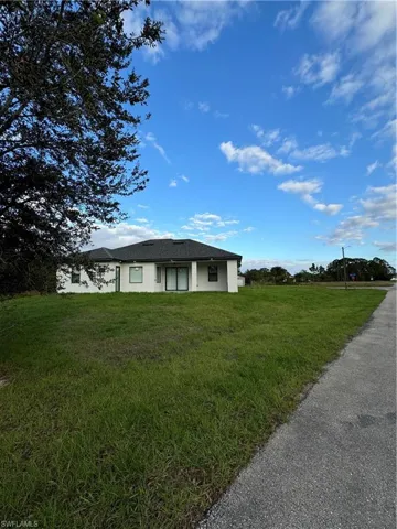 View of backyard of home featuring a back lawn