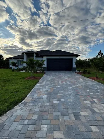 Ranch-style house featuring a garage and a front yard