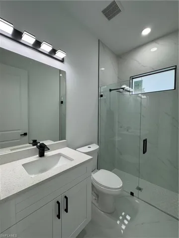 Bathroom with vanity, toilet, and walk in shower