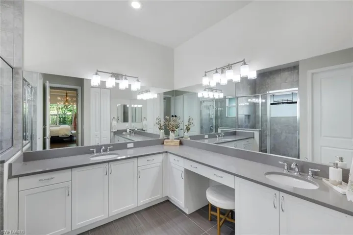 Leading to your primary en-suite bathroom are two large walk-in closets! Lovely counter space with built-in sitting area. Two separate sinks, recessed lighting and tasteful vanity fixtures, wonderful cabinet and counter space!