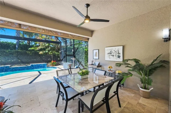 Welcome to your outdoor oasis complete with hurricane protection and plumbed for gas for summer kitchen option! Spacious out door space with wonderful covered area, travertine floors, 2 ceiling/light fans, gorgeous pool and picture window pool screen!