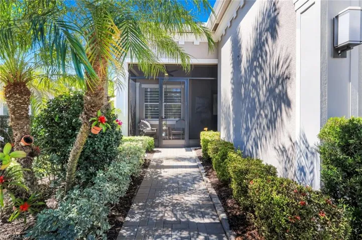 A Brick Paver walkway surrounded by orchids hanging from lush palm trees delight as you approach the entryway