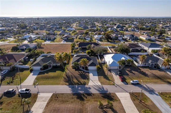 Aerial view of property and surrounding area featuring nearby suburban area