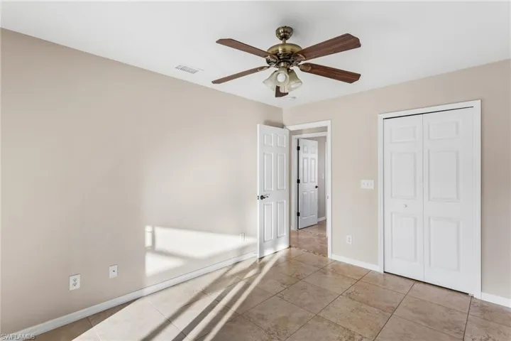 Unfurnished bedroom featuring ceiling fan, a closet, and tile patterned flooring