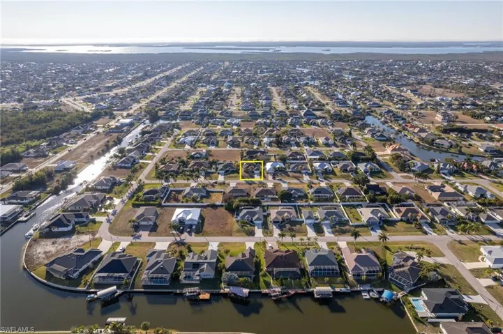 Aerial view of property and surrounding area featuring nearby suburban area