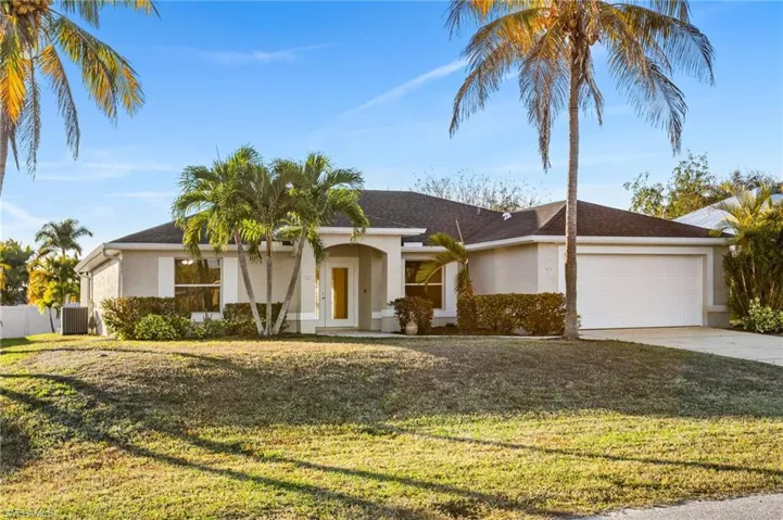 Single story home with stucco siding, driveway, a garage, and a front yard