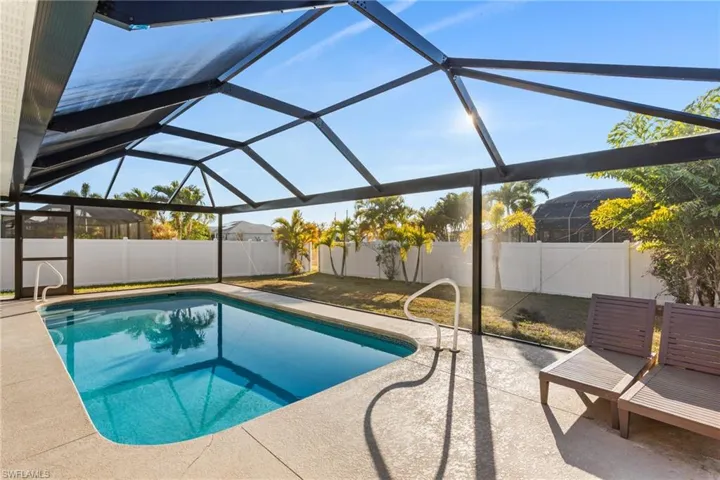 View of pool featuring a lanai, a sunroom, a fenced backyard, and patio surround