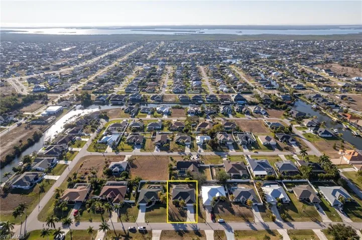 Aerial perspective of suburban area featuring property parcel outlined and a large body of water