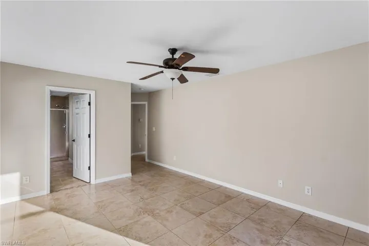 Unfurnished bedroom with a ceiling fan and baseboards
