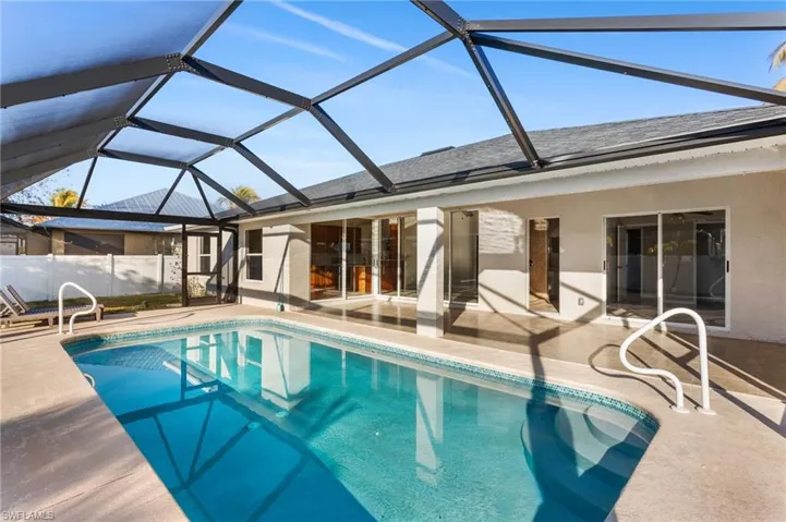 Swimming pool featuring a sunroom, a lanai, and a patio area