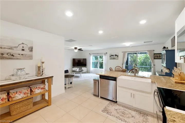 Kitchen with a peninsula, light stone countertops, appliances with stainless steel finishes, recessed lighting, and light tile patterned floors