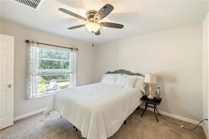Carpeted bedroom featuring baseboards and a ceiling fan