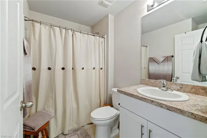 Full bathroom with vanity and curtained shower