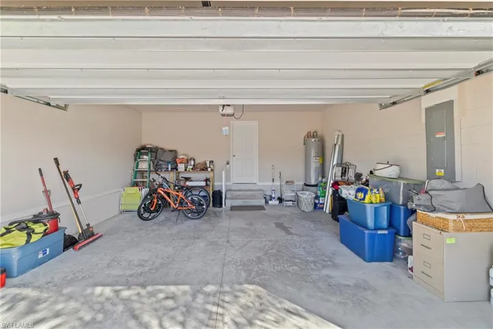 Garage featuring electric panel and electric water heater