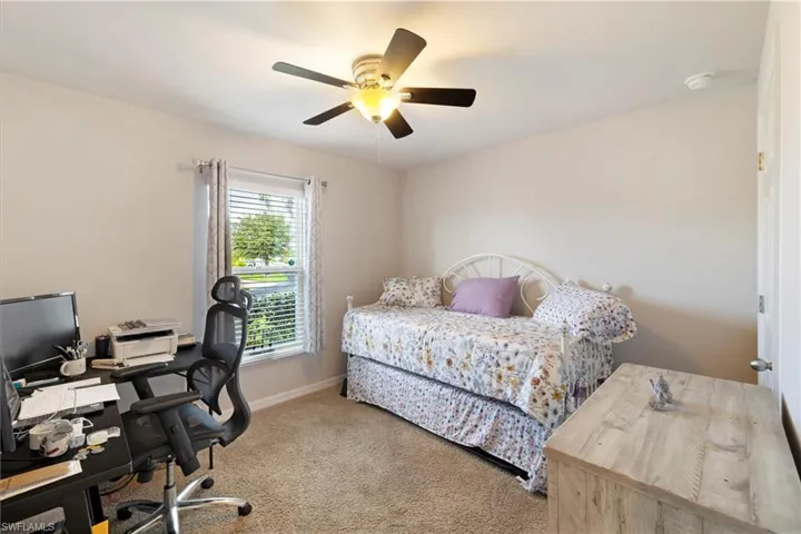 Bedroom with carpet, a desk, and a ceiling fan